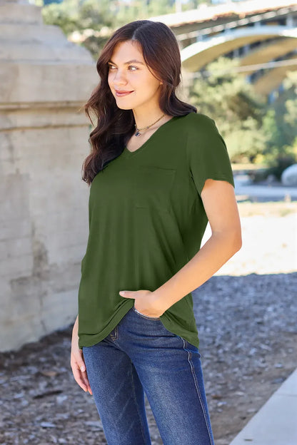 Woman outdoors wearing olive green short sleeve pocket tee and blue jeans