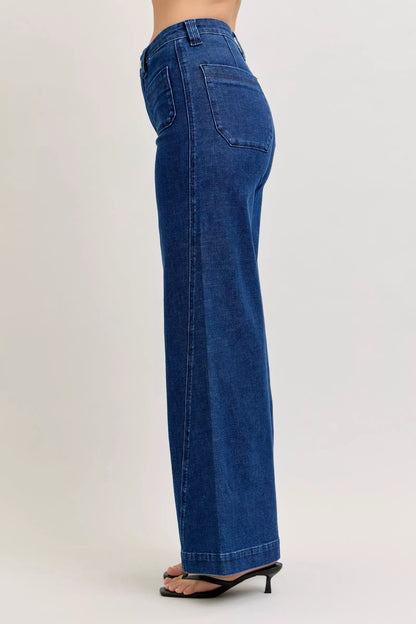 Woman wearing high-waisted wide leg blue jeans with back pockets and black heeled sandals