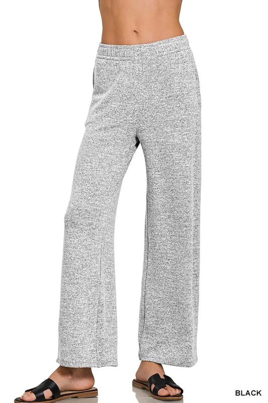 Woman wearing relaxed fit heather grey lounge pants with elastic waistband and black sandals