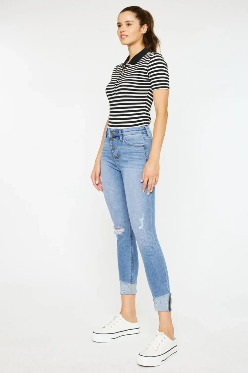 Woman wearing black and white striped polo shirt with light blue high-waisted skinny jeans