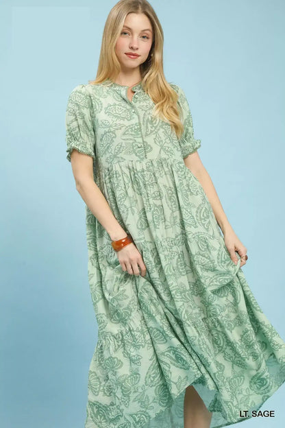 Woman wearing an Umgee Paisley Print Tiered Midi Dress on a blue background 