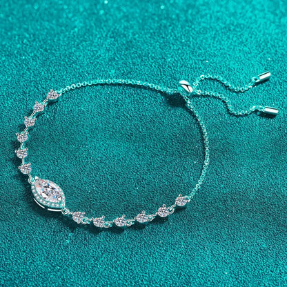 Delicate adjustable silver bracelet with marquise and round crystals on teal textured background.