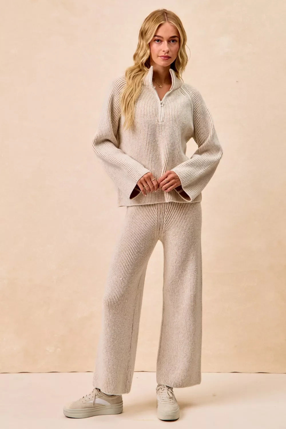 Woman wearing a beige ribbed knit lounge set with wide-leg pants and collared sweater