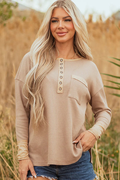 Woman in beige waffle knit henley top with front buttons, outdoors in casual summer style