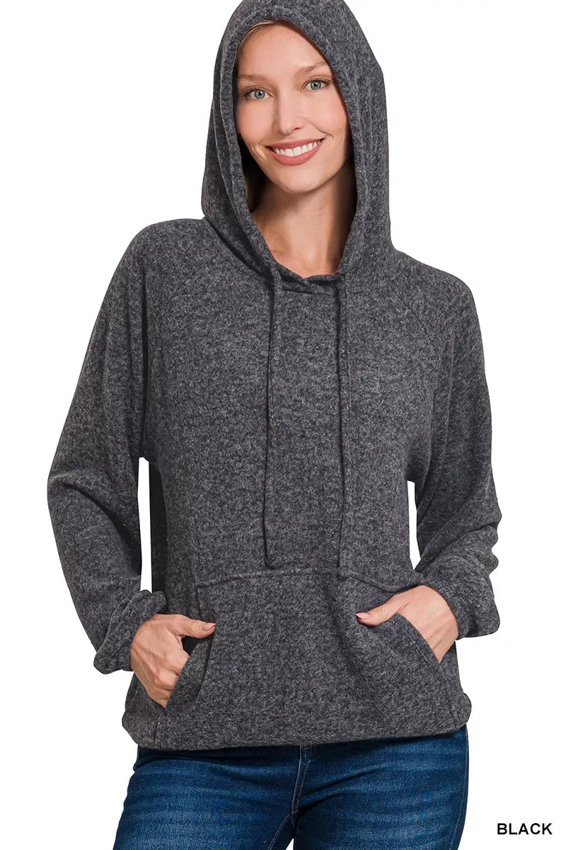Woman wearing a charcoal gray hooded sweater with front pocket and relaxed fit