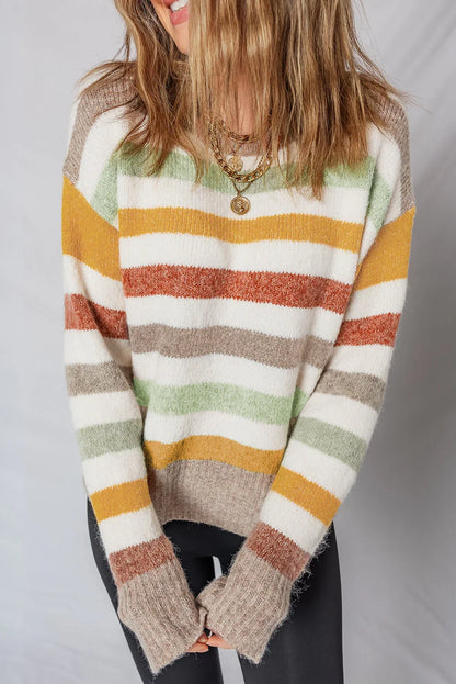 Woman wearing a cozy striped sweater with earthy tones and layered gold necklaces