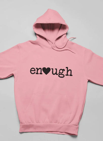 Pink hoodie with 'enough' text and heart graphic on front, laid flat on gray background.
