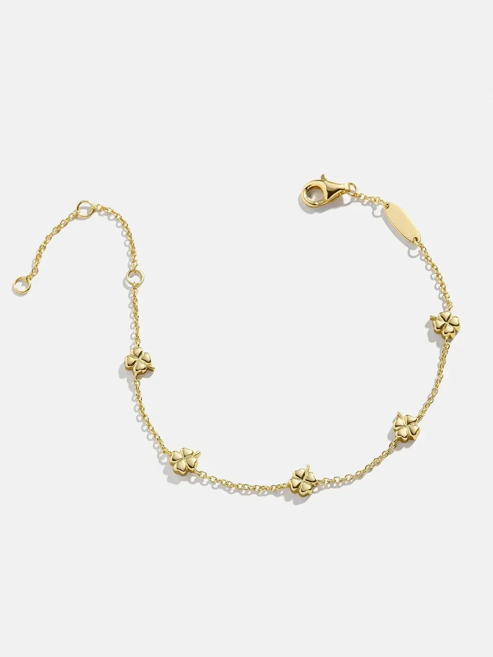 Delicate gold chain bracelet with small flower charms on a white background