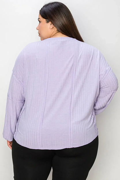 Back view of woman wearing a lilac ribbed long sleeve top and black pants