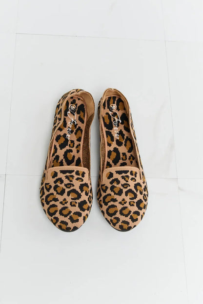 Leopard print women’s flats with round toe on white tile floor