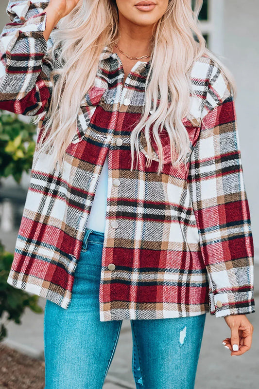 Woman wearing a red plaid flannel jacket and blue distressed jeans outdoors