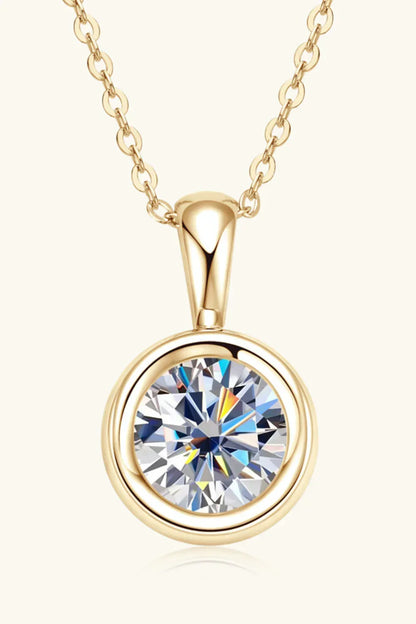 Gold chain necklace with round solitaire crystal pendant on a light background
