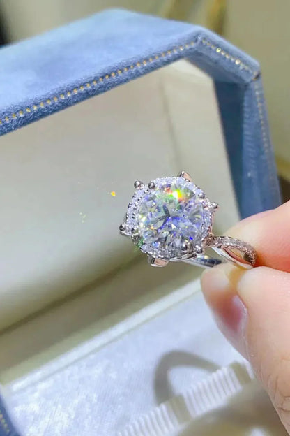Close-up of a sparkling round-cut diamond ring with halo setting in a blue jewelry box