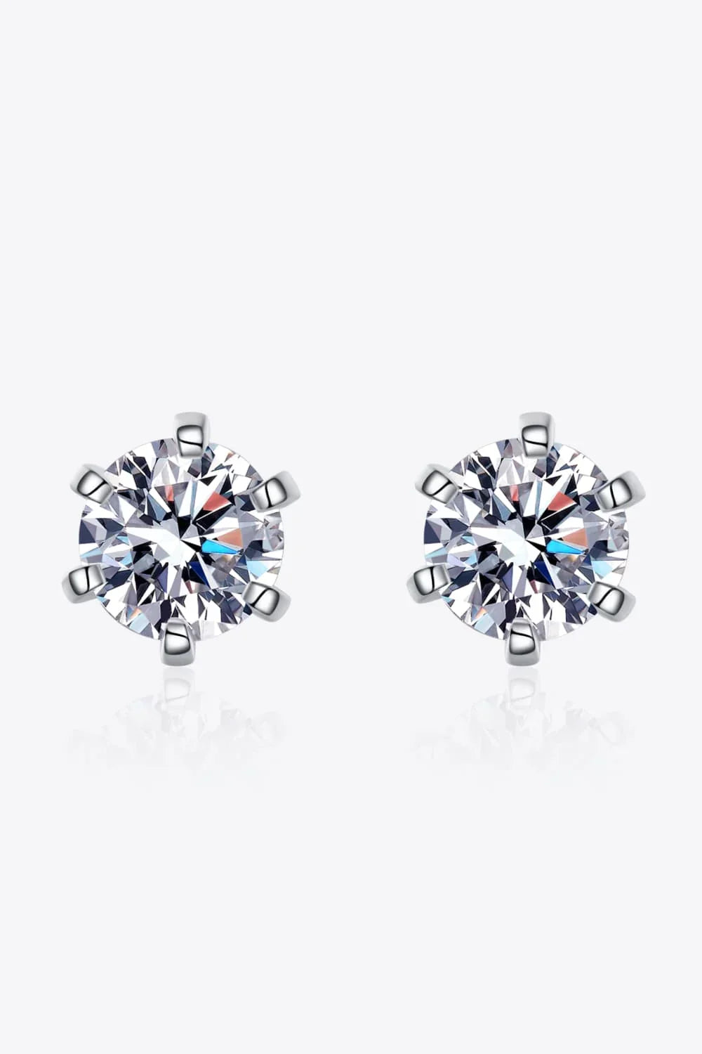 Round cut solitaire stud earrings with silver prong setting on white background