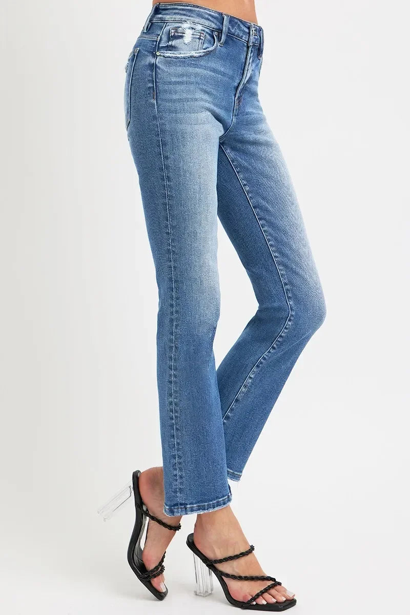 Woman wearing straight leg blue jeans with slight distressing and black heeled sandals