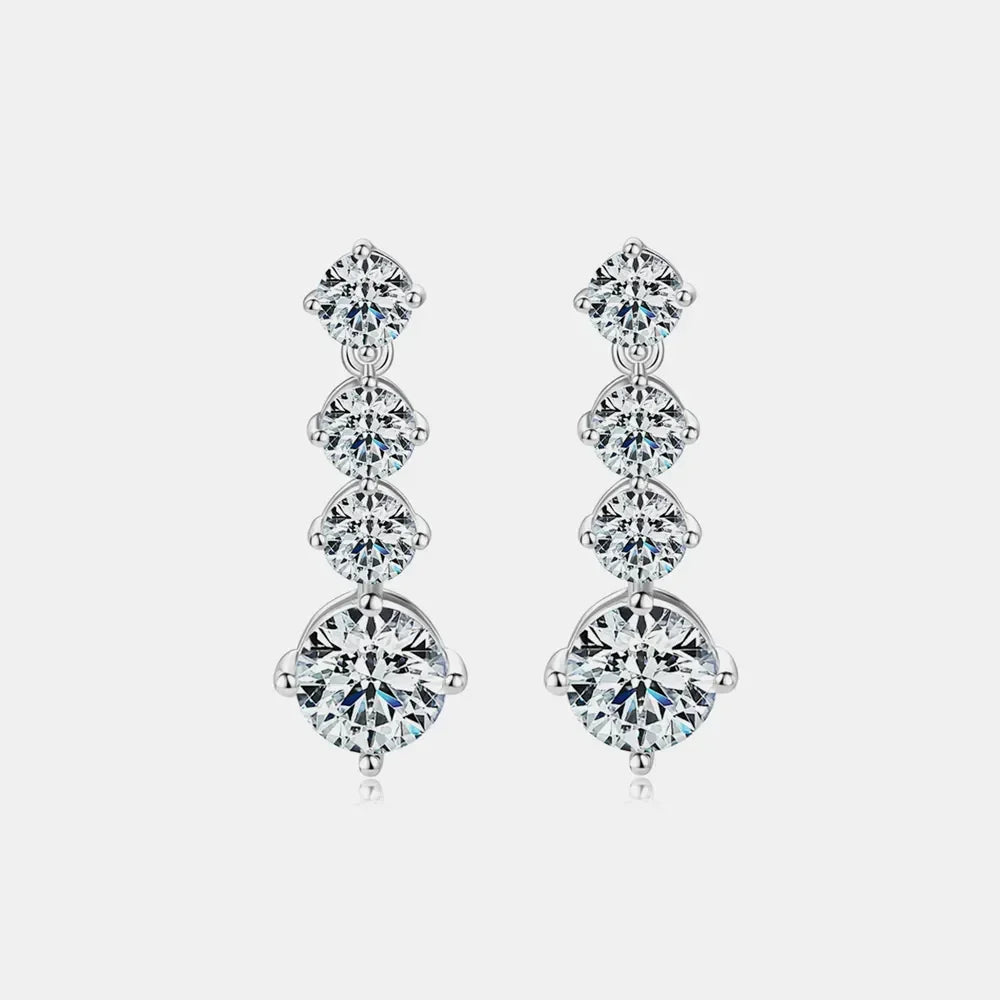 Elegant silver drop earrings with four round, graduated cubic zirconia stones on white background.