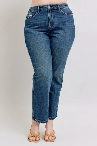 High-waisted straight leg blue jeans styled with tan sandals on a woman